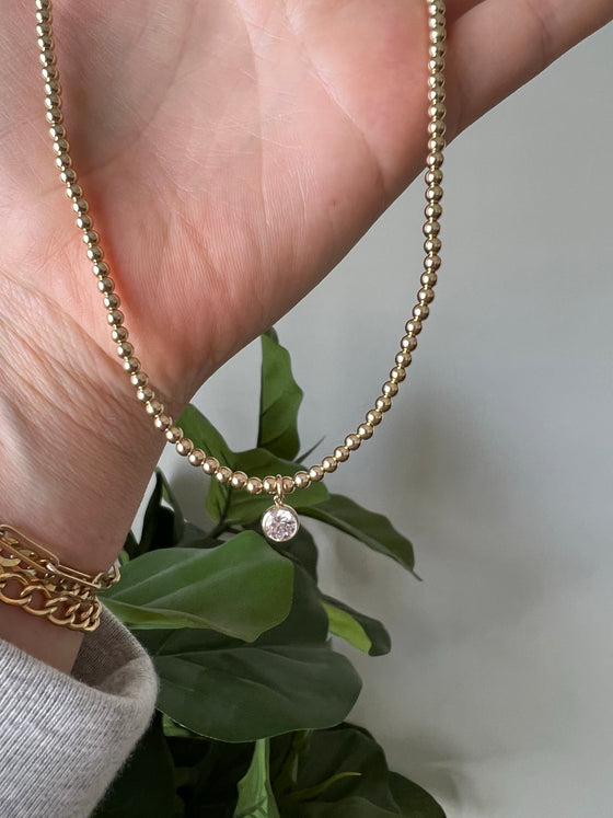 Gold beaded charm necklace