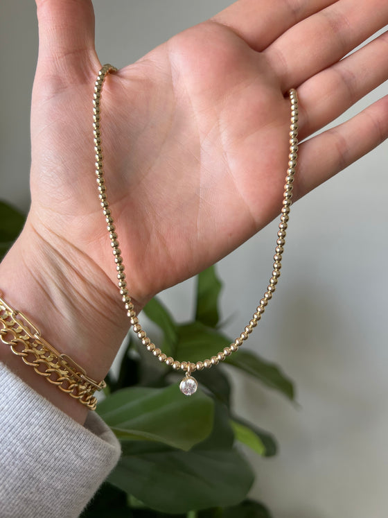 Gold beaded charm necklace